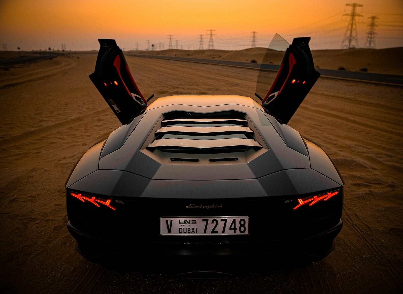 Lamborghini Aventador S with scissor doors open at sunset