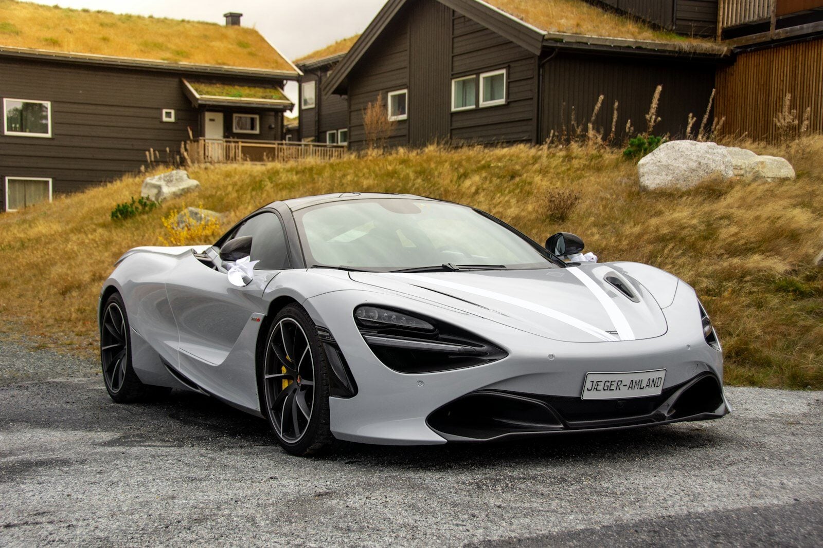 White McLaren 720S parked in front of a house
