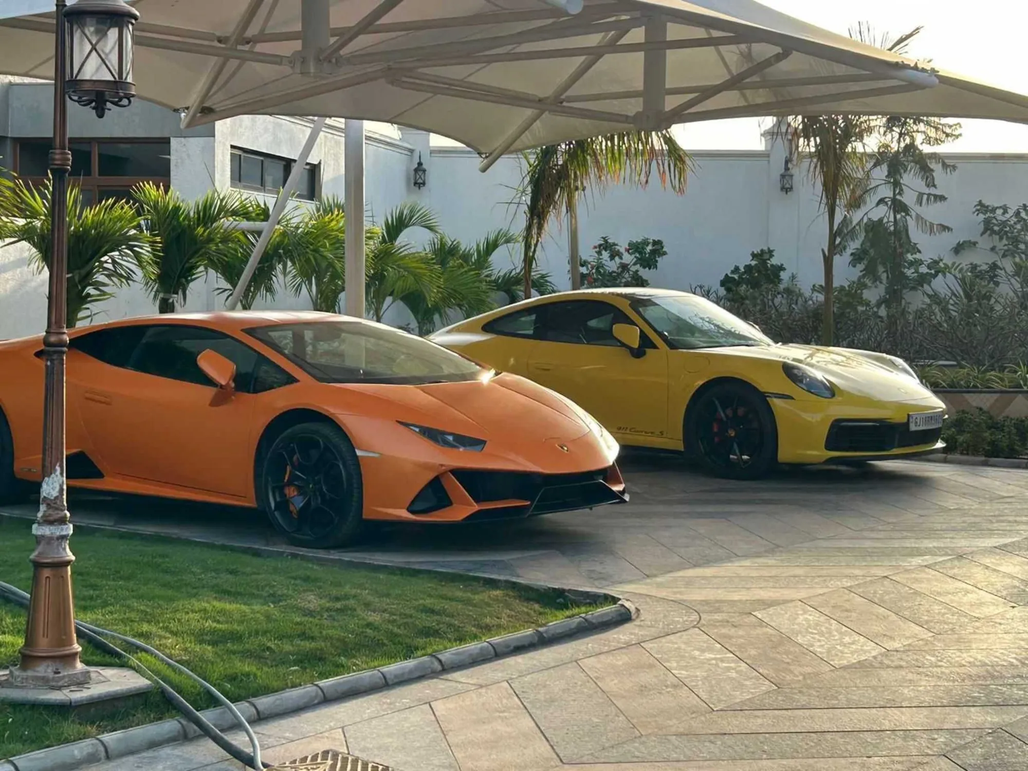 Orange Lamborghini Huracán EVO parked under palm trees